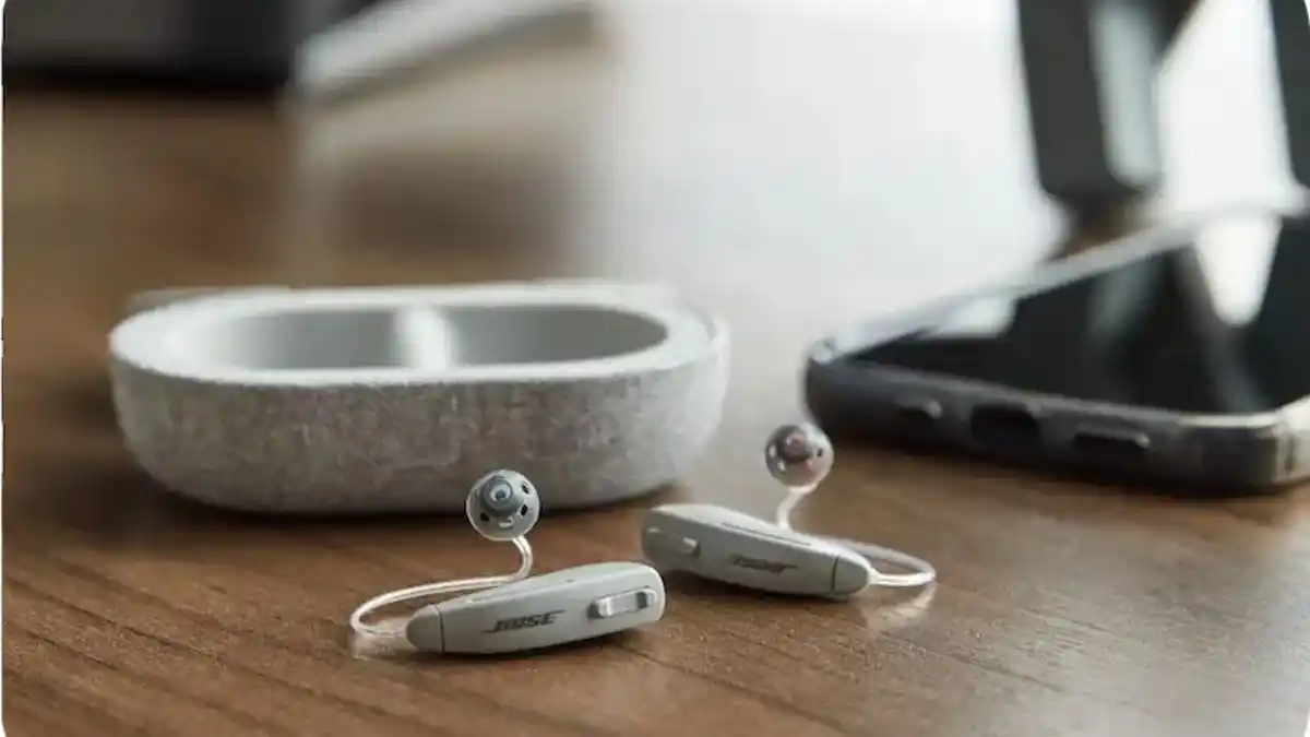 Lexie B1 Powered by Bose hearing aids with carrying case in background.