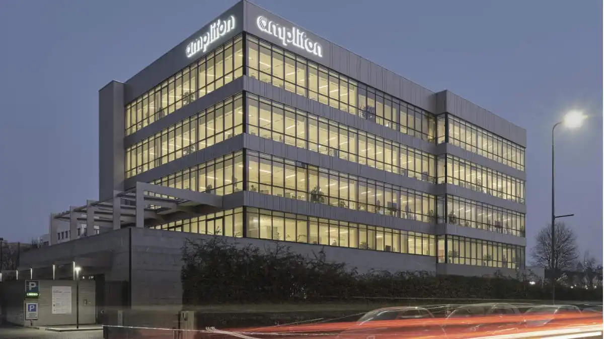 Night photo of modern-looking Amplifon headquarters in Milan, Italy