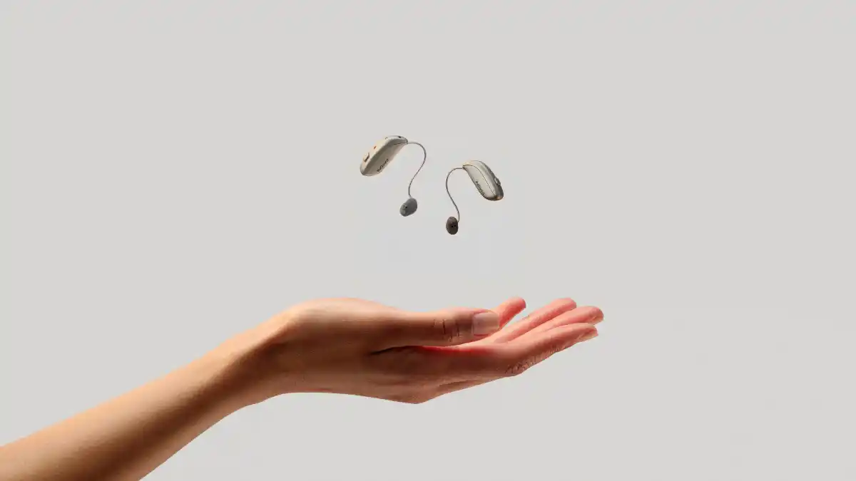 Sensia earing aids lifting off a person's hands