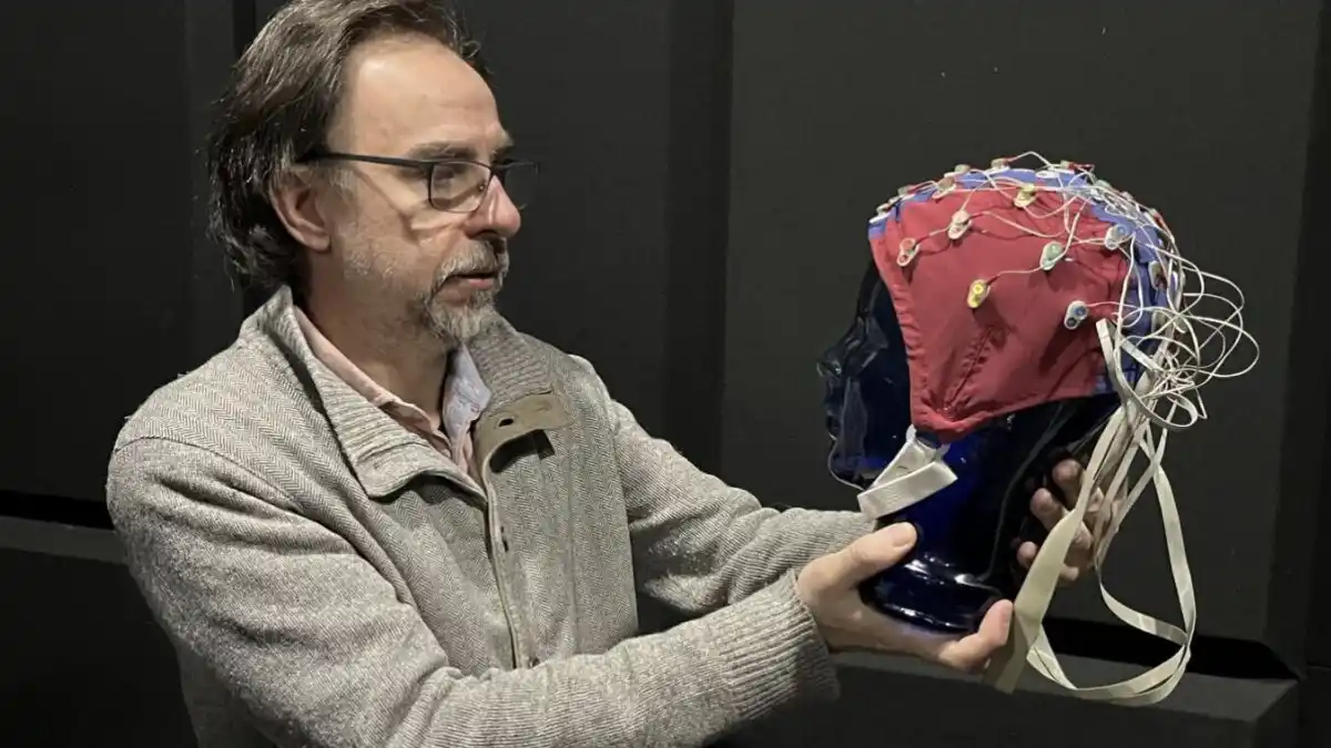Western University professor Andrea Soddu holds a simulation head with an EEG cap.  Photo by Jeff Renaud.