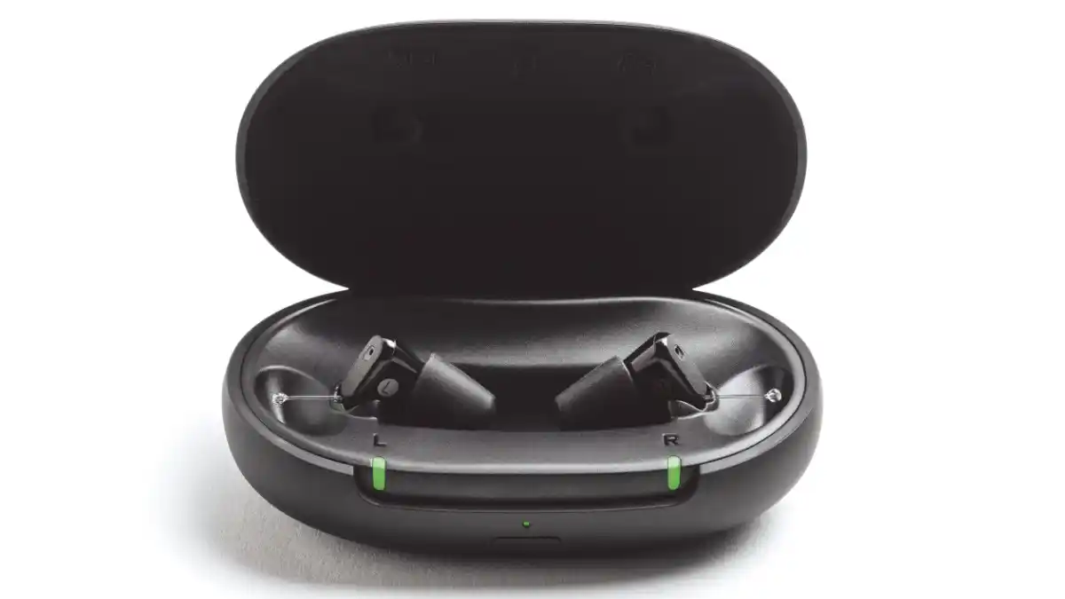 Two black Sony CRE-C20 hearing aids in oval portable charging case