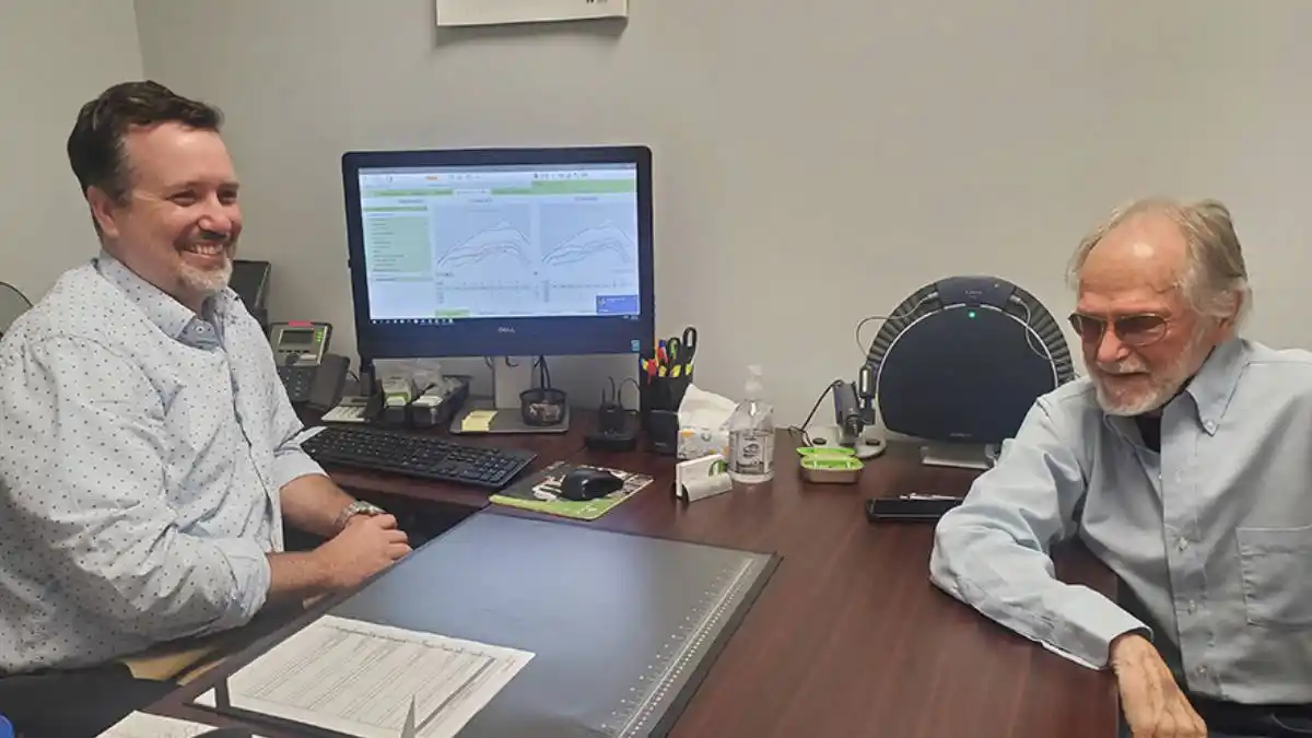 A Connect Hearing provider chats with a client during a follow-up visit.