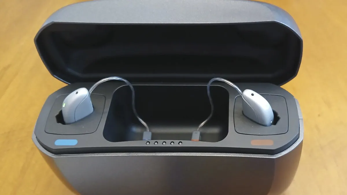 The Jabra Enhance Select 500 hearing aids in their recharging case which holds 3 extra charges.