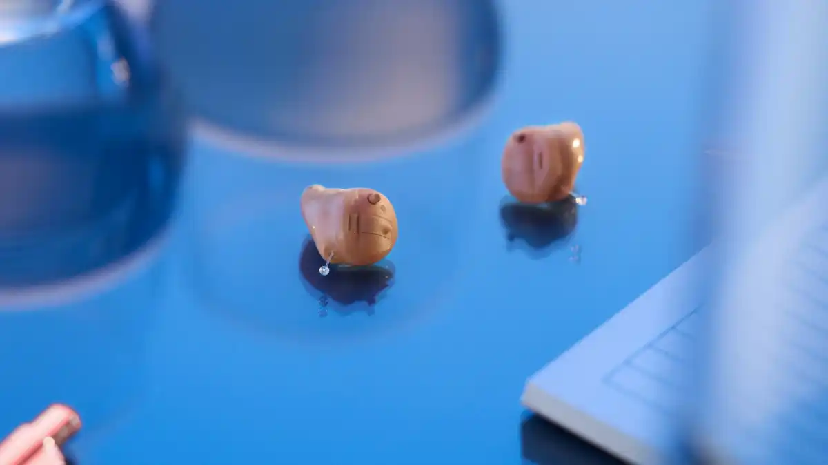 Small in-ear Savi ITC hearing aids on blue background