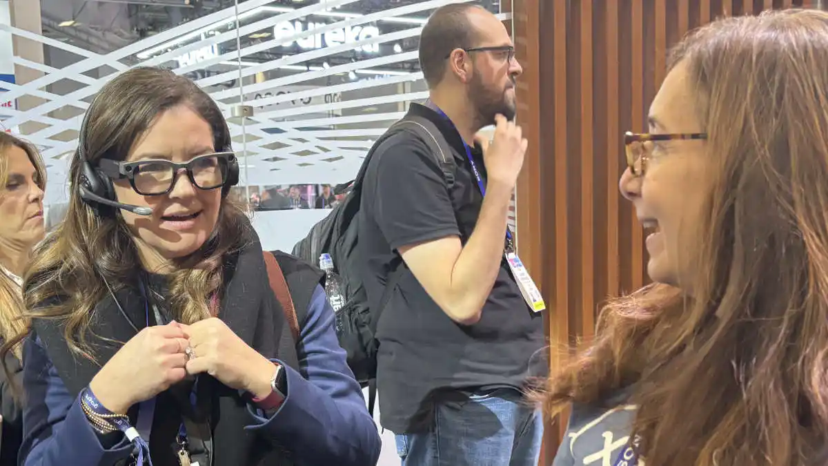 Woman with set of Xander glasses speaking with Xander's Marilyn Westner