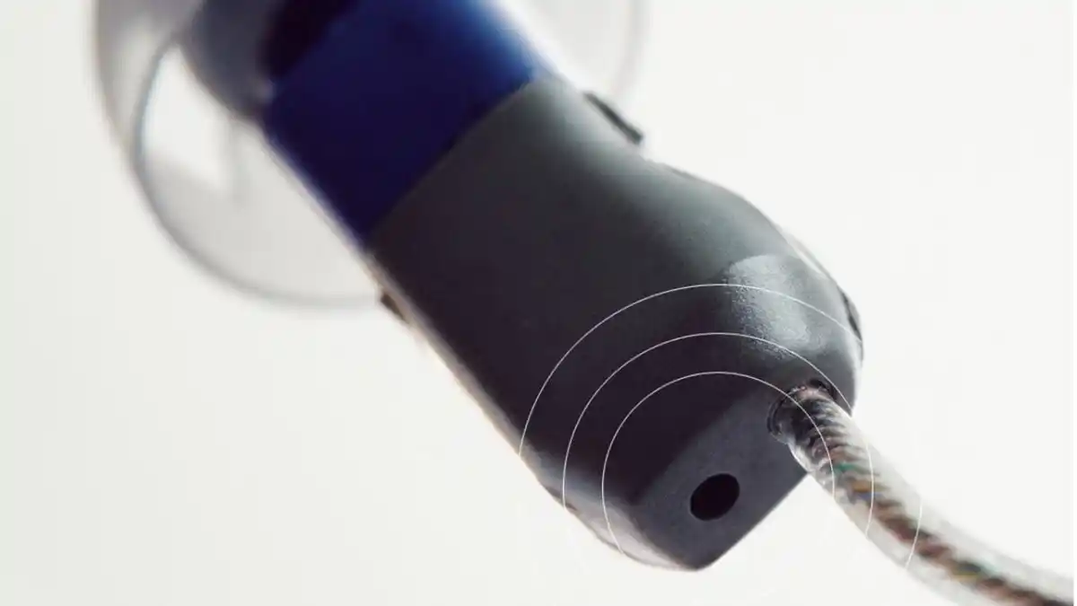 Die in Beltone Achieve verwendete M&RIE-Technologie verfügt zusätzlich zu den beiden Mikrofonen auf der Oberseite des Receiver-in-Ear (RIE) Hörgeräts über ein drittes Mikrofon (den Mikrofonanschluss am unteren Rand des Fotos), das Geräusche auf Höhe Ihres Gehörgangs aufnimmt.