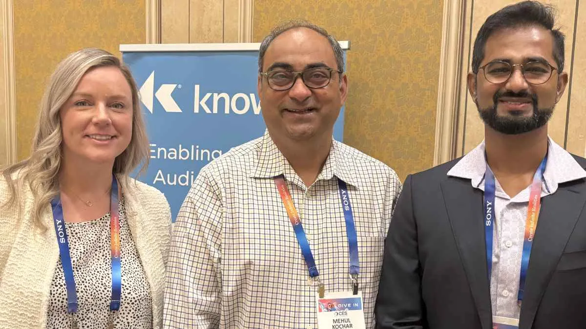 Photo of Knowles Alex Crabb, Mehul Kochar, and Kalyan Nadella in front of blue Knowles banner