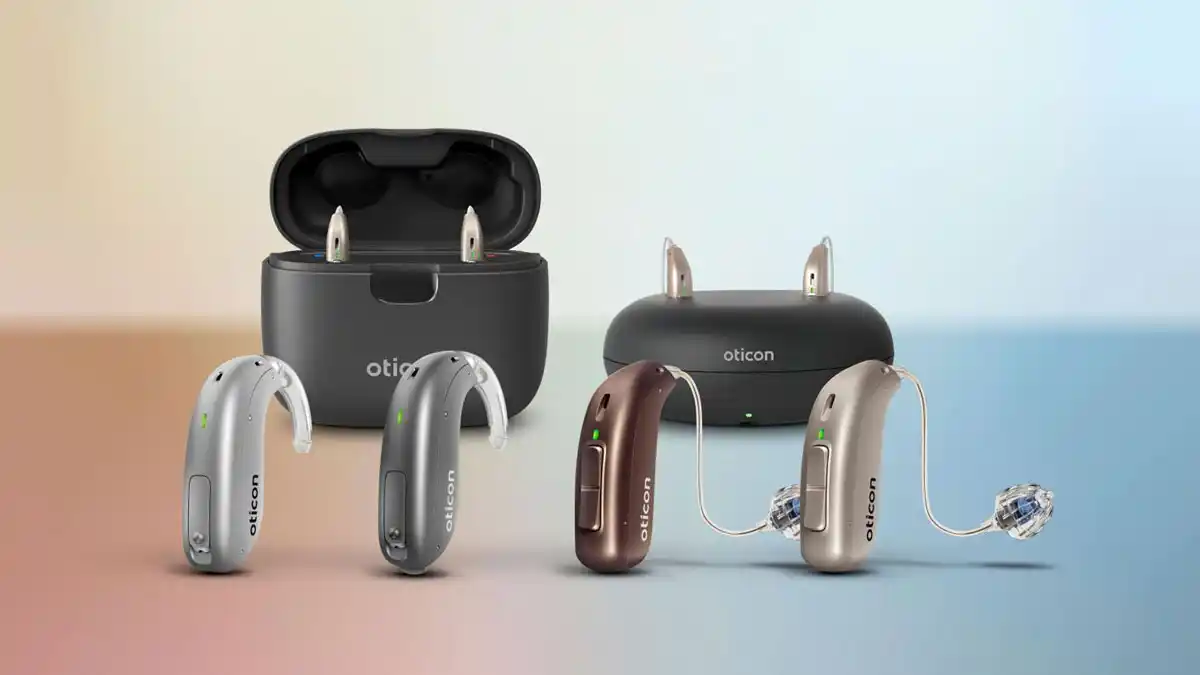 Oticon Real family of BTEs and RITEs with the Smartcharger and standard desktop charger in the background.