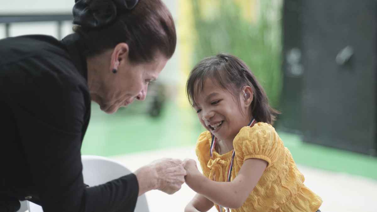 Starkey Hearing Foundation Co-Founder Tani Austin celebrates a young girl's new hearing aids.