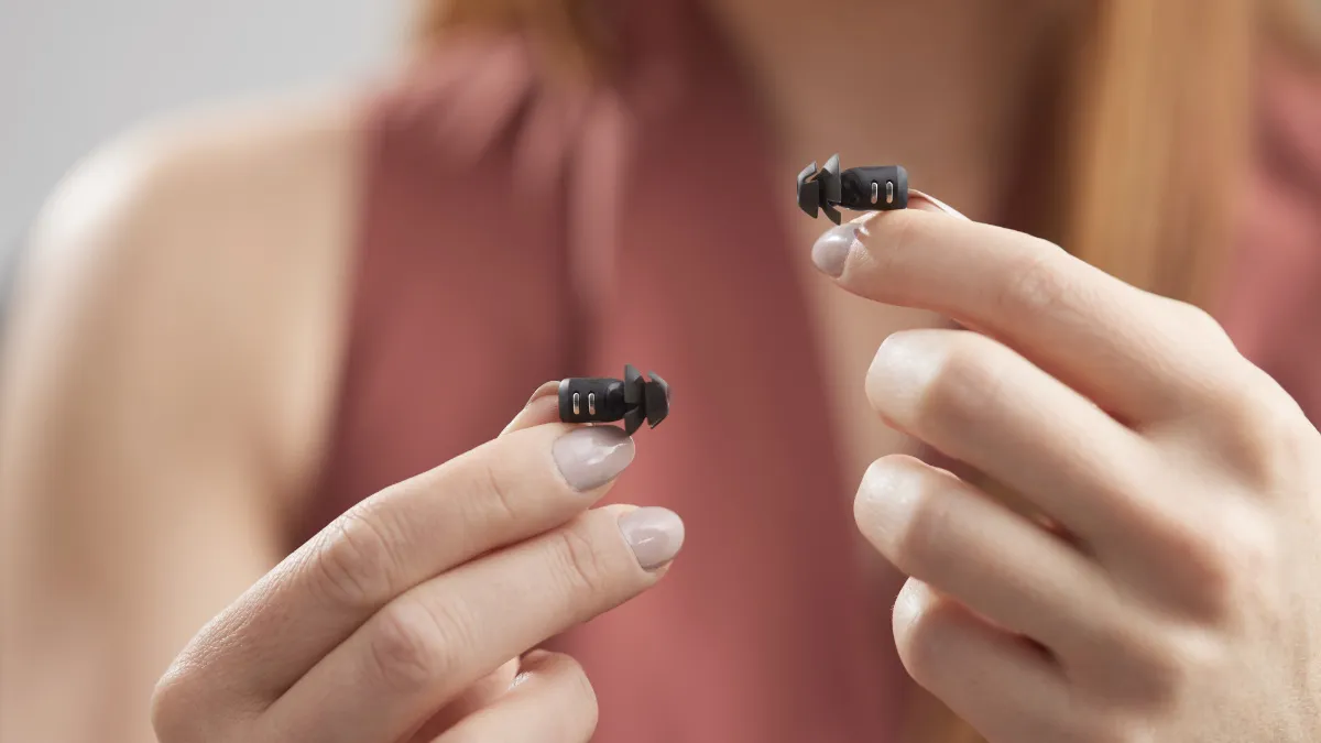 The extremely small Eargo 7 hearing aids in the palm of a hand