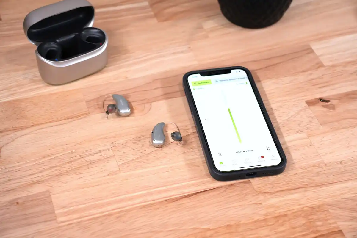 Infinio Ultra Sphere next to iPhone displaying myPhonak app