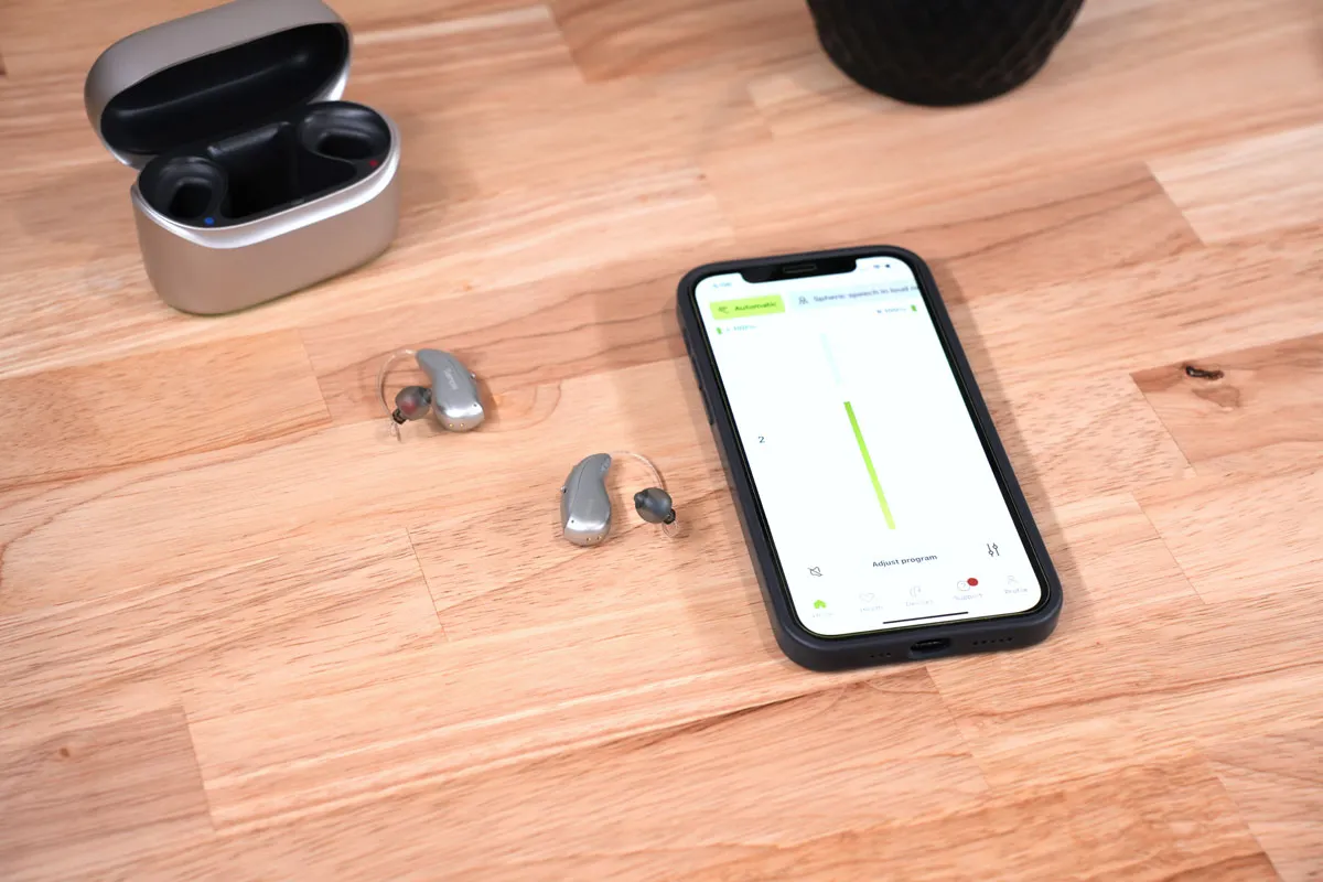 Infinio Ultra Sphere next to iPhone displaying myPhonak app