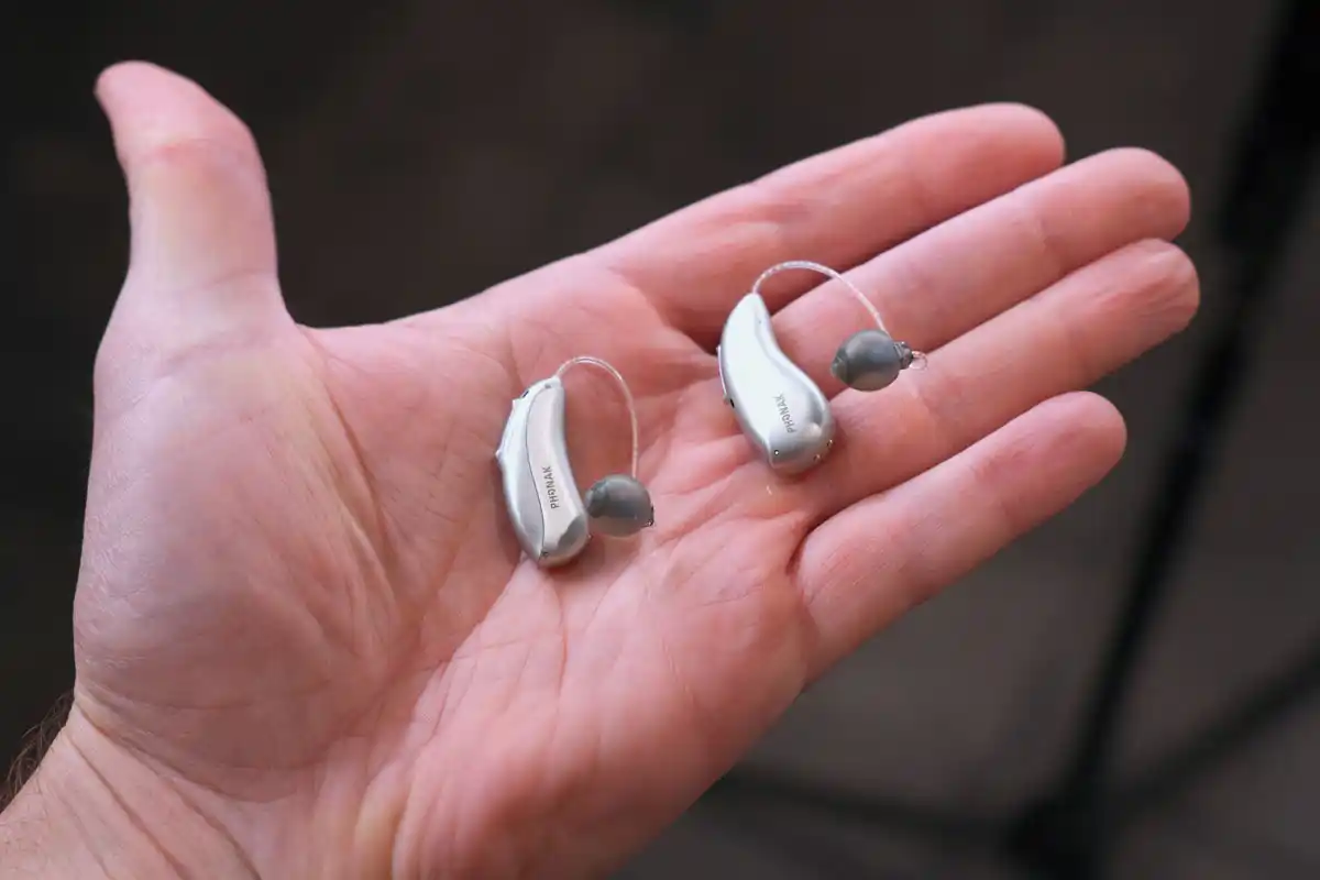 Pair of Infinio Ultra Sphere hearing aids in hand