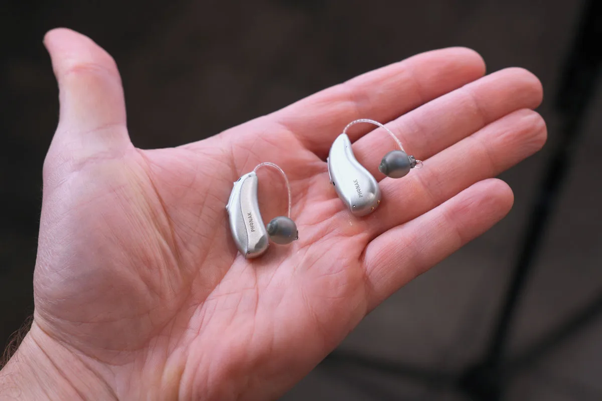 Pair of Infinio Ultra Sphere hearing aids in hand