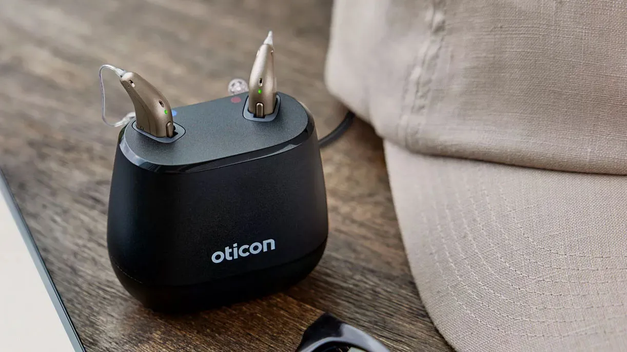 The Oticon Intent desktop charger uses inductive charging to provide faster charges than contactless inductive charging, providing 4 hours of use time with a 15-minute charge. Magnets are used to ensure tight contact.