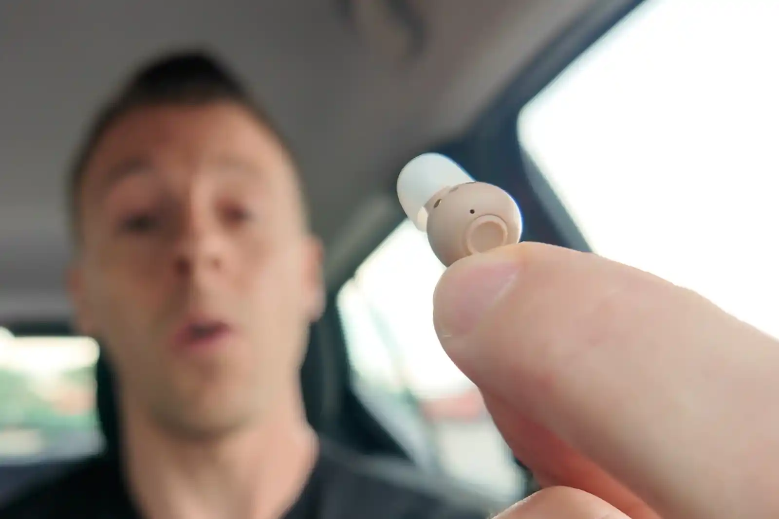 Audien Atom Pro 2 hearing aids are relatively small. Here, you can see it in my fingers, with a good look at the control button on the ITE/earbud faceplate.