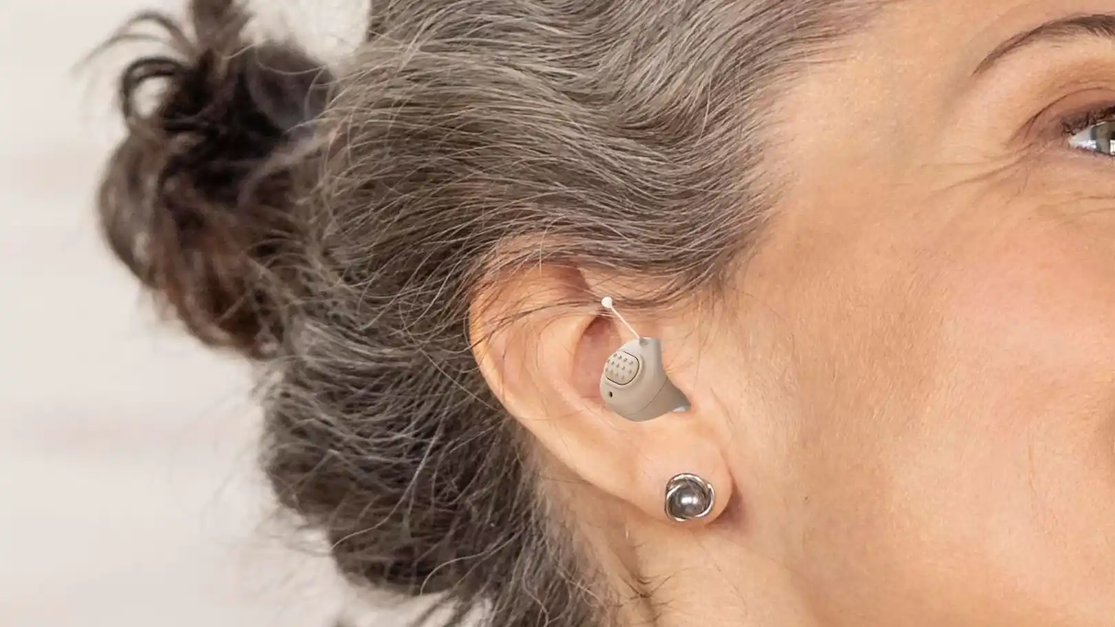Sharper Image's earbud style hearing aid offers up to 16 hours of battery life per charge, but it does not support Bluetooth streaming. Note that their visuals showing people wearing the company's hearing aids appear to be photo montages.