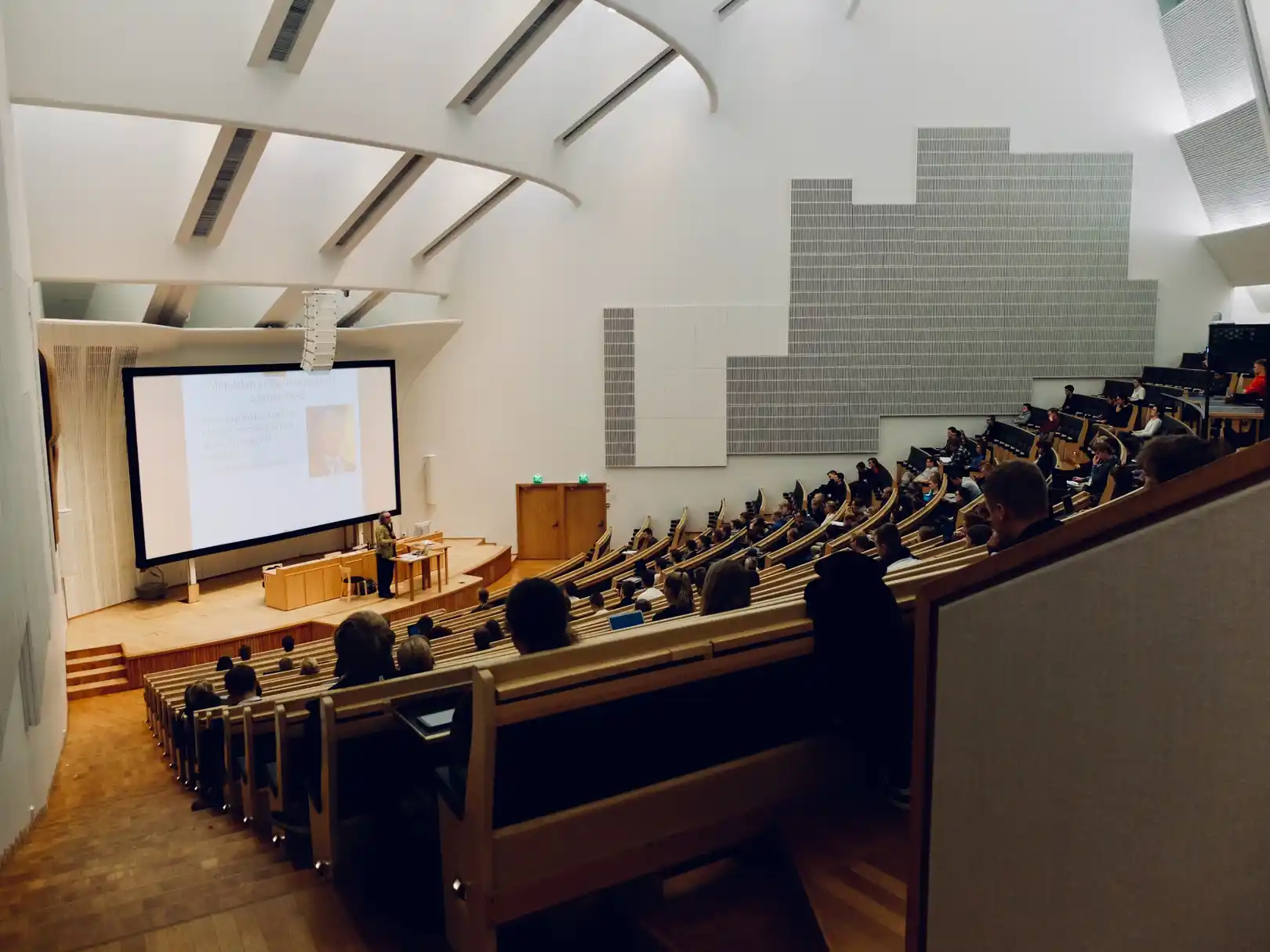 Lecture halls, theaters, and other large-area venues where hearing can be difficult due to distance and reverberation are greatly aided by loop systems for people with telecoil-enabled hearing aids and cochlear implants.
