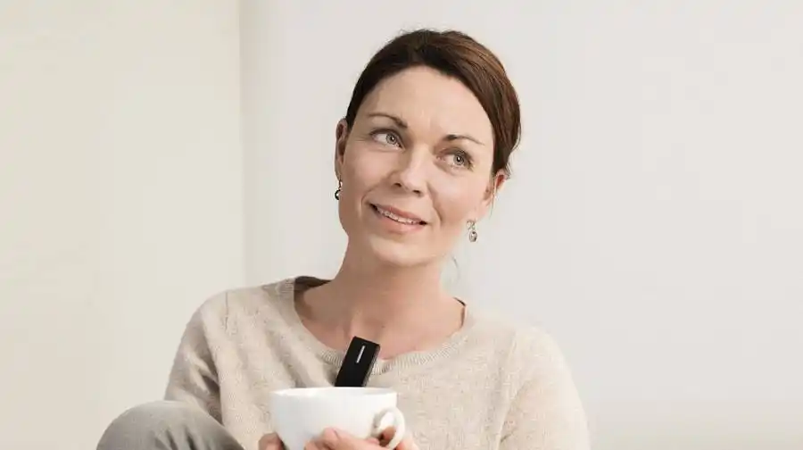 Eine Frau verwendet ein Oticon ConnectClip-Fernmikrofon