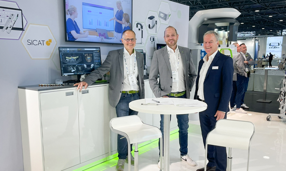 Klaus Maier, Andreas Brandstätter und Jochen Kusch (v.l.n.r ) lachen in die Kamera vor dem SICAT-Messestand.