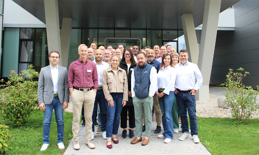 The group of visitors has gathered in front of the headquarters and is smiling at the camera.