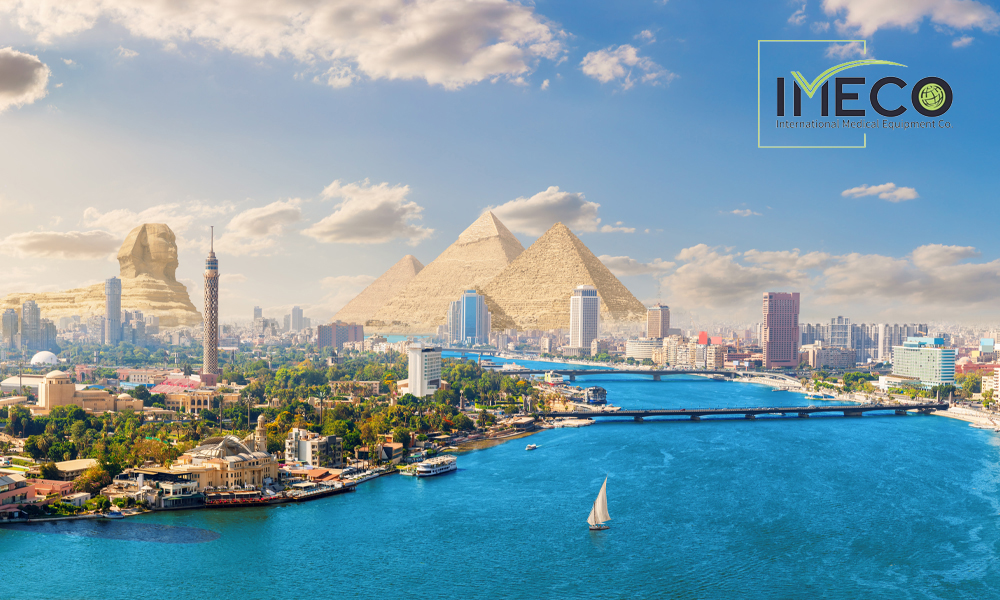 Panoramic view of Cairo featuring the Nile River, modern city skyline, the Cairo Tower, the Great Pyramids of Giza, and the Great Sphinx under a bright blue sky with scattered clouds.