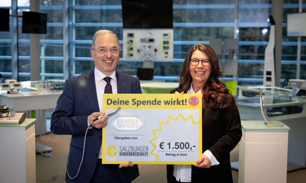 Im Bild (v.l.n.r.): W&H Geschäftsführer Dipl.-Ing. Peter Malata und Obfrau der Salzburger Kinderkrebshilfe Claudia Kopp lächeln in die Kamera mit dem Scheck in der Hand.