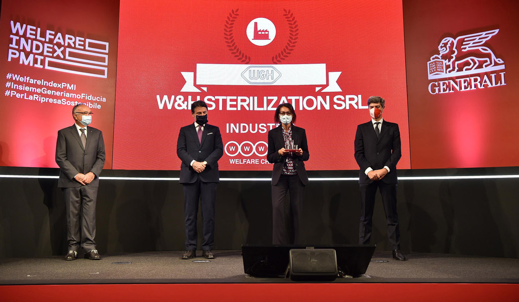 Elena Ferrari, miembro de Recursos Humanos en W&H Sterilization, aceptó con orgullo el premio del presidente del Consejo de Ministros, Giuseppe Conte. En la foto, de izquierda a derecha: Stanislao Di Piazza (ministro de Trabajo y Políticas Sociales), Giuseppe Conte, Elena Ferrari y Marco Sesana (director nacional y director ejecutivo de Generali Italia y Global Business Lines).  © Generali Italia
