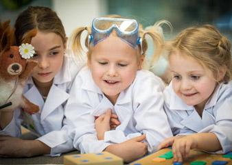 Emma Unger programerar roboten. Från vänster: Viola Malata och systrarna Emma och Matilda Unger.