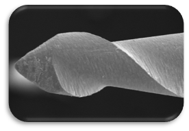  Lime endodontique neuve, agrandie 100 fois, sur fond sombre