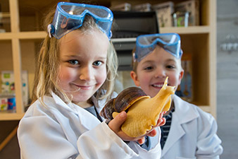 Amelie Kogler gently handles the giant African snail and is obviously not afraid to touch it. Fellow pupil Paul Wallner finds the giant snail equally enthralling.