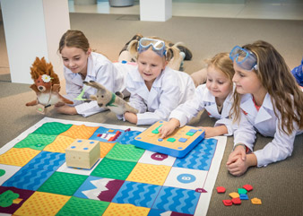 Emma Unger drückt den Startknopf und der Roboter führt ganz autonom die programmierten Bewegungen aus. Im Bild v.li.: Viola Malata und die drei Schwestern Emma, Matilda und Aurelia Unger.