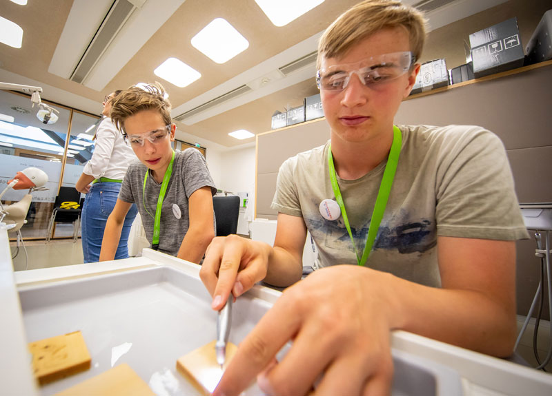 Die Jugendlichen schlüpfen in die Rolle des Zahnarztes – jetzt ist präzises Arbeiten gefragt.