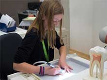 Schülerin der Salis beim Bohren mit einem W&H Winkelstück.