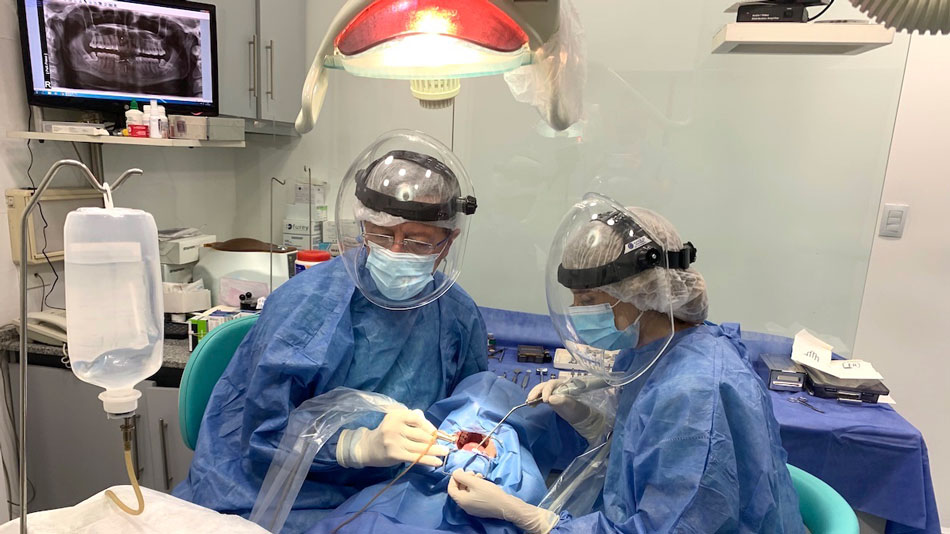 El Dr. Ibáñez durante la colocación de un implante dental en su clínica.