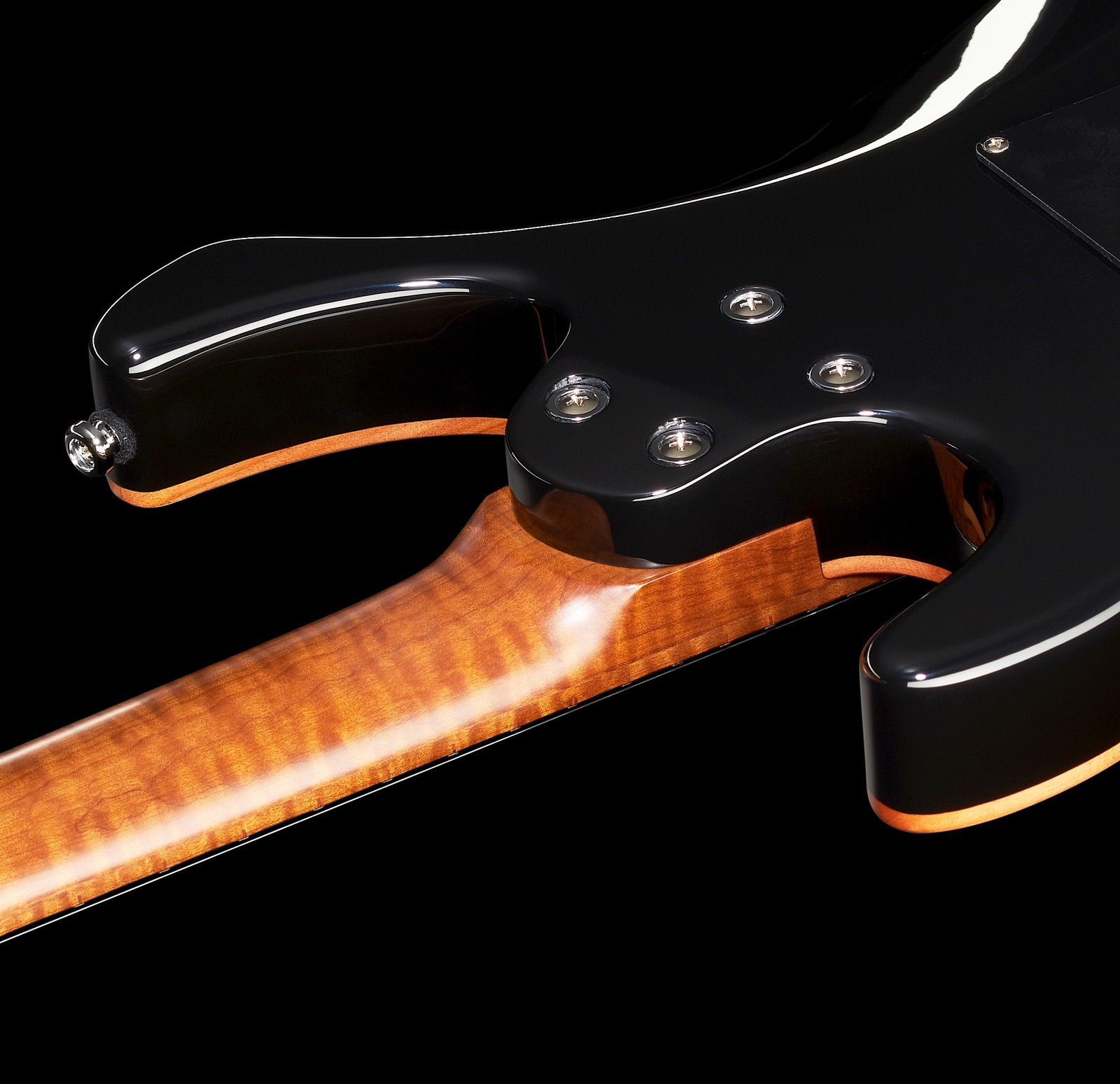 Vue de derrière du corps noir de la guitare électrique vissé au manche en érable ondé