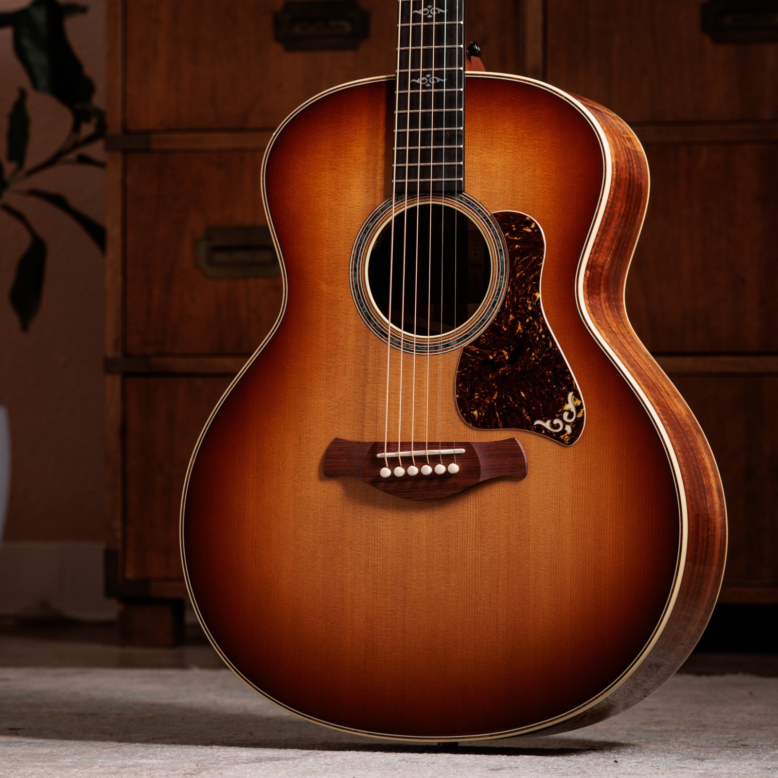 Korpus und Fichtendecke der Taylor Gold Label 814e Koa Sunburst in einem Wohnzimmer