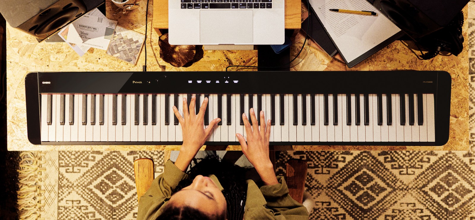 Frau spielt Digital Piano Casio PX-S5000 auf einem selbstgebauten Schreibtisch, Ansicht von oben