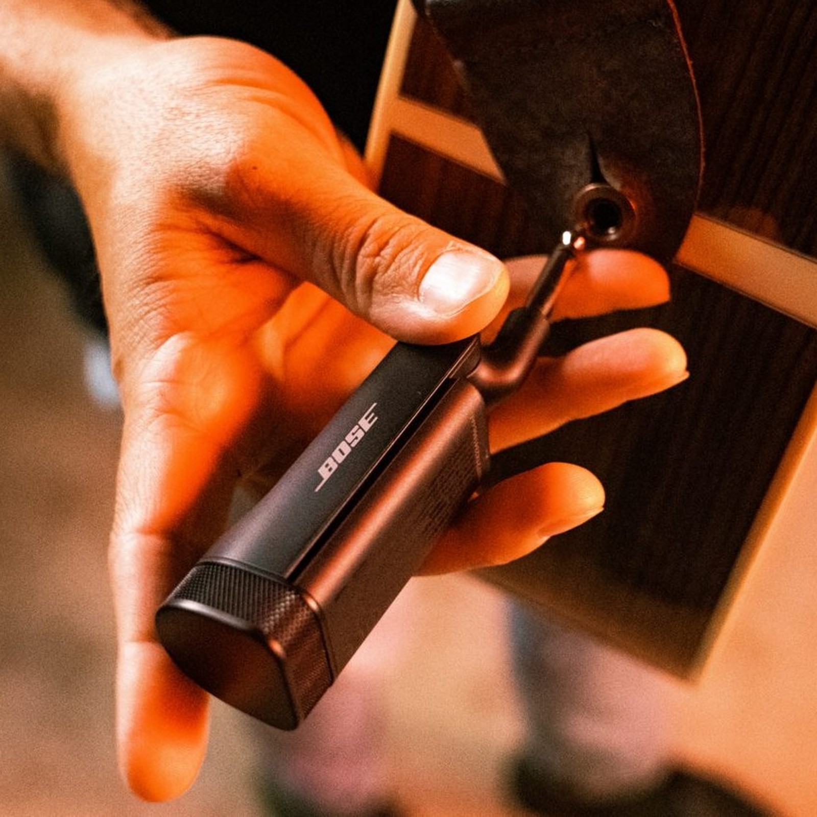 Bose S1 Pro PIus Instrument Transmitter wird an eine Akustikgitarre angeschlossen