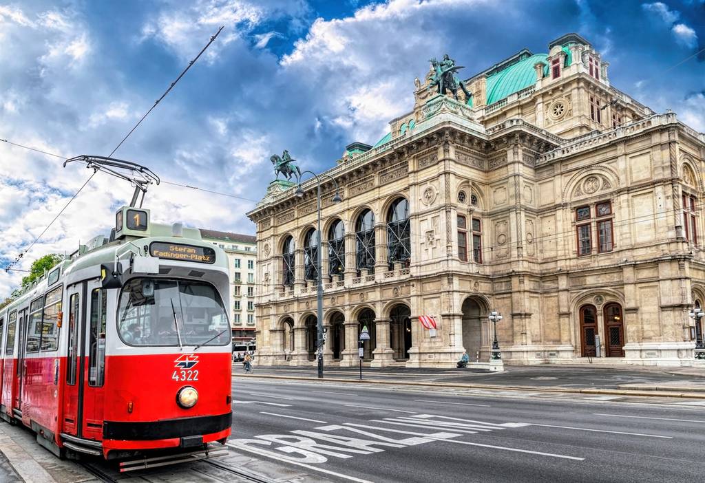Blick auf das Opernhaus in Wien und eine rote Strassenbahn