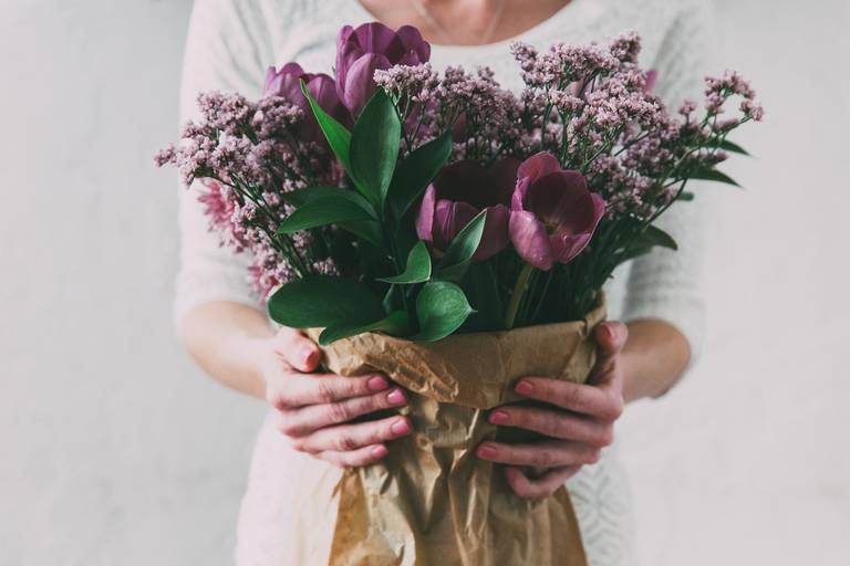 Vrouw met een boeket paarse tulpen