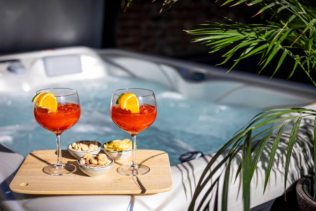 Borrelplankje met cocktails op de rand van een whirlpool