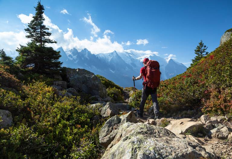 Wanderer in der Bergwelt mit Blick auf schneebedeckte Gipfel