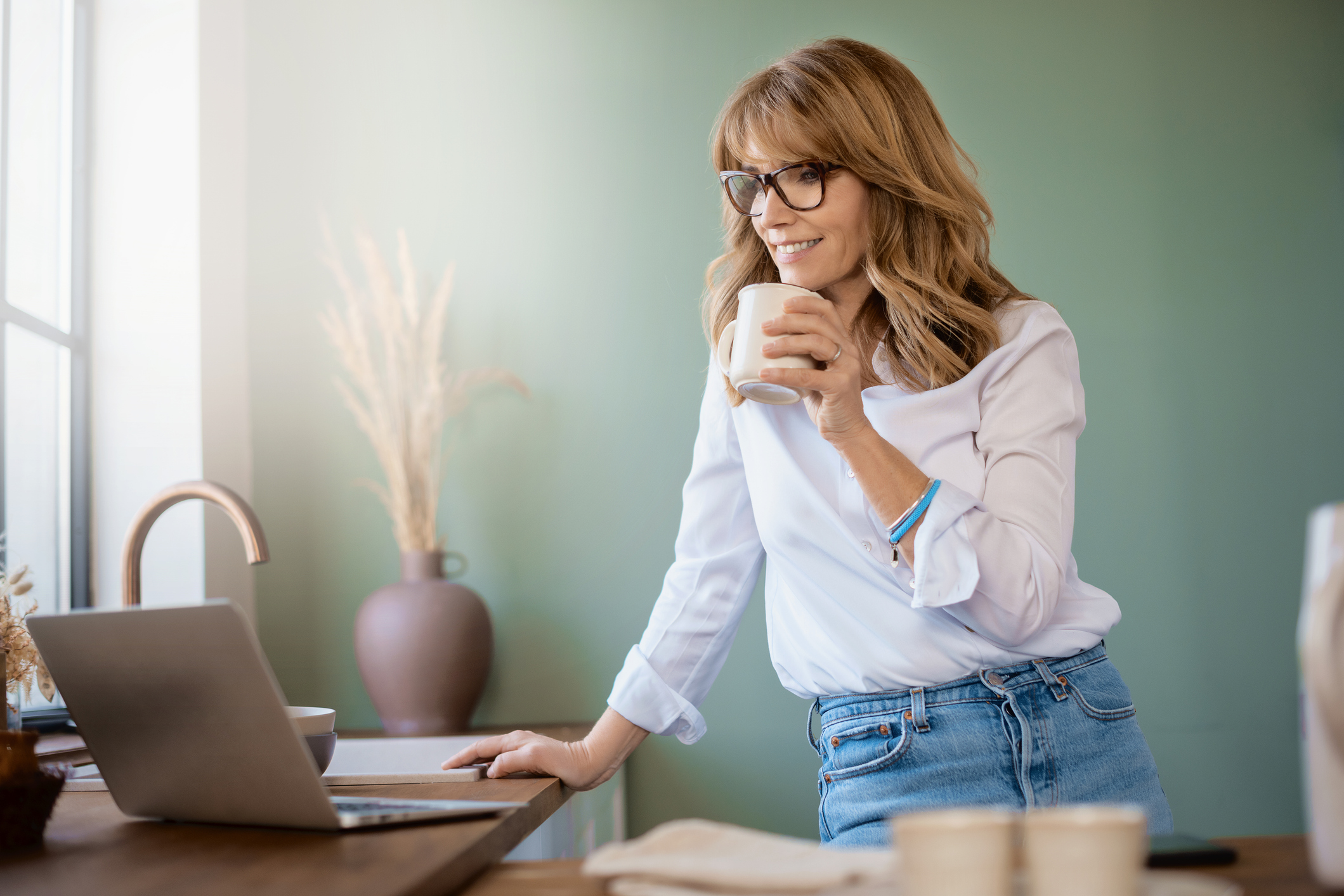 Vrouw zoekt via haar laptop naar meer informatie over het runnen van een B&B