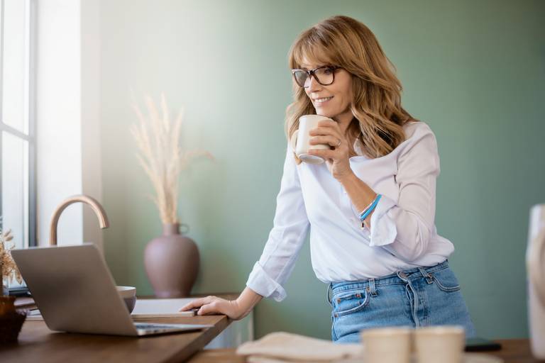 Vrouw zoekt via haar laptop naar meer informatie over het runnen van een B&B