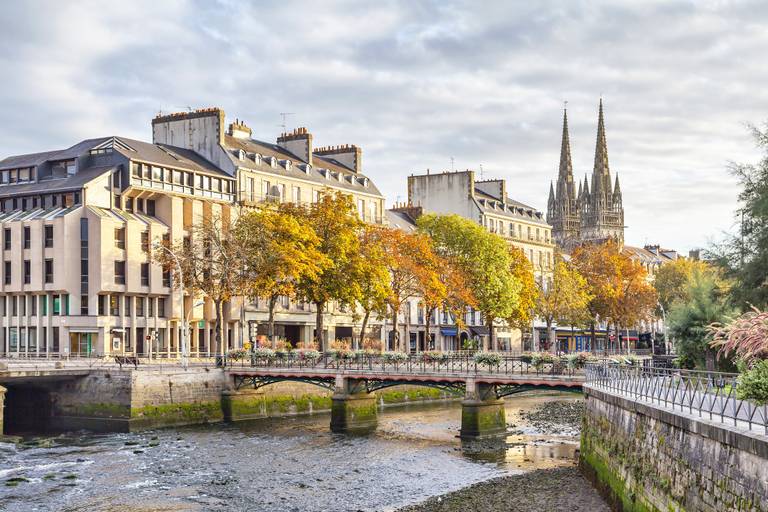 Landschaftliche Ansicht einer europäischen Stadt mit einem Fluss, einer Bogenbrücke, historischen Gebäuden