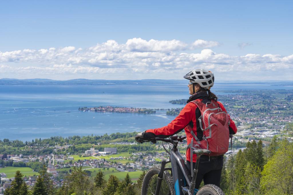 Radfahrerin die über den Bodensee blickt