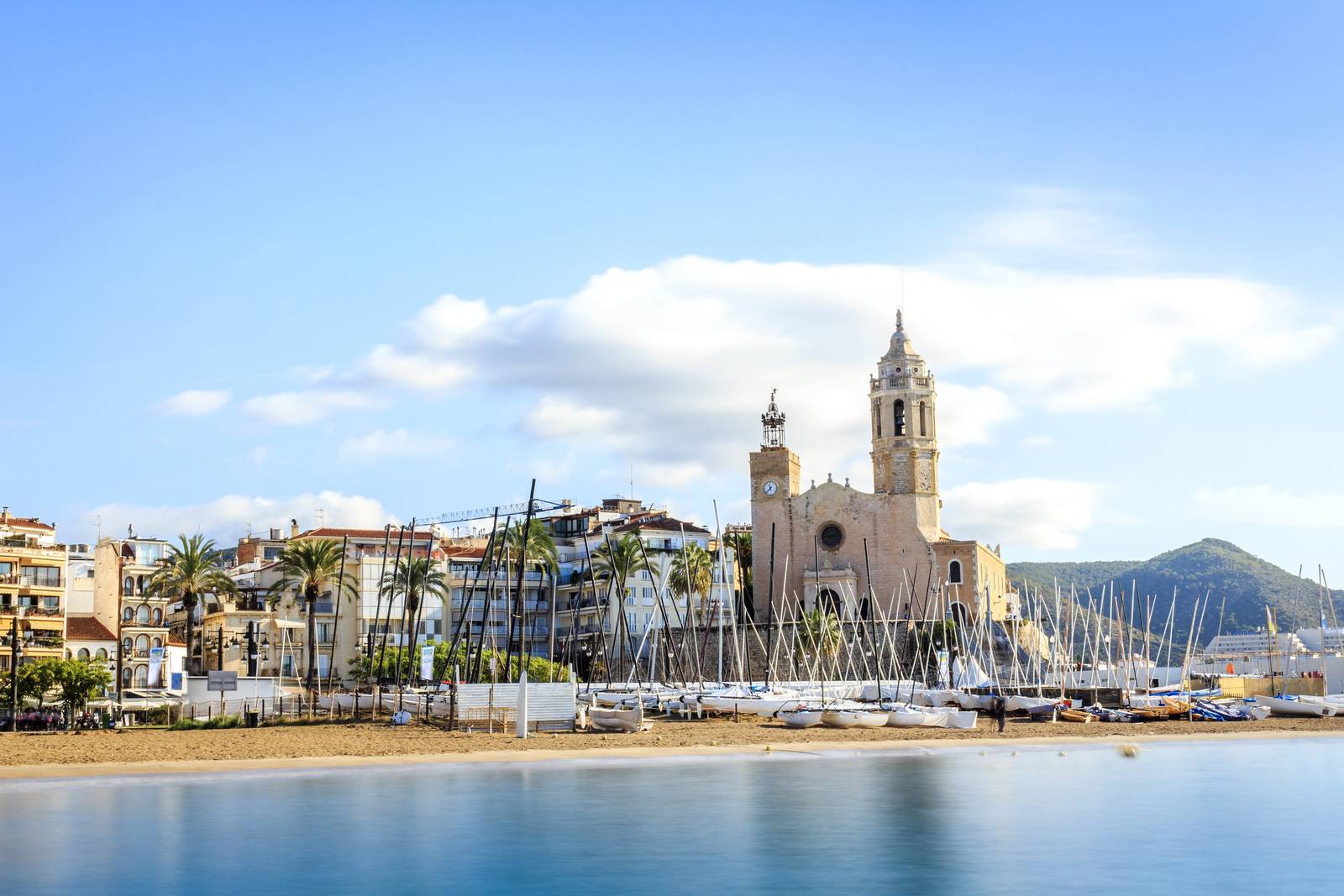 Playa, barcos e iglesia en Sitges en Barcelona