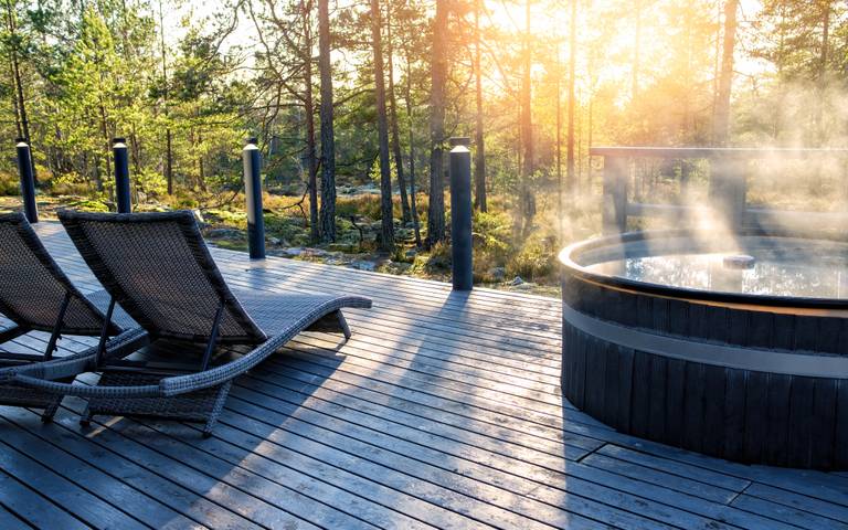 Ligbedden en een hot tub op een vlonder in de natuur