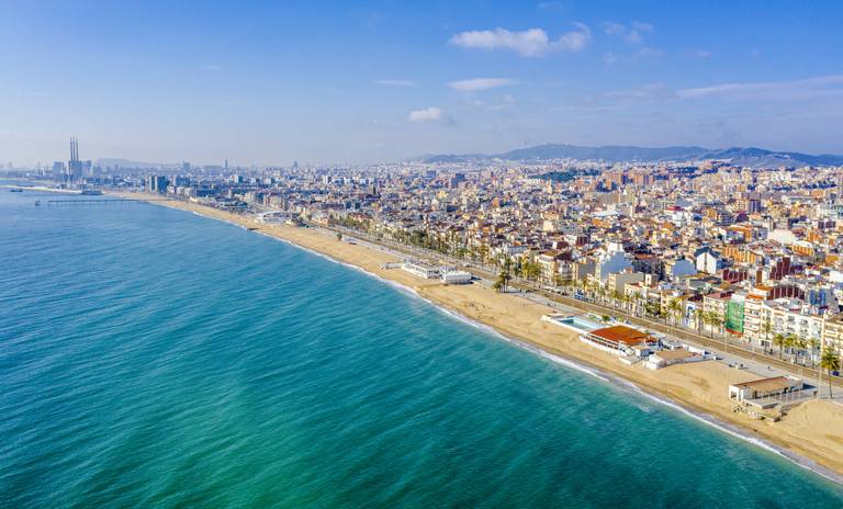 Vista aerea de la playa de Badalona con las tres chimeneas de fondo